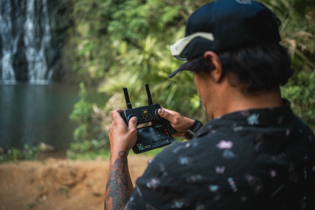 Thiago Silva operating a drone beside a waterfall in New Zealand